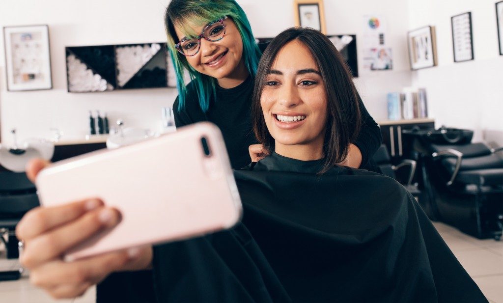 Woman taking a photo of her newly cut hair