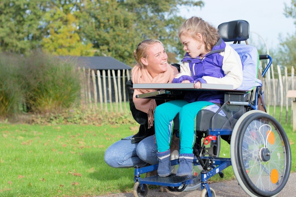 a woman with her child riding a mobility scooter