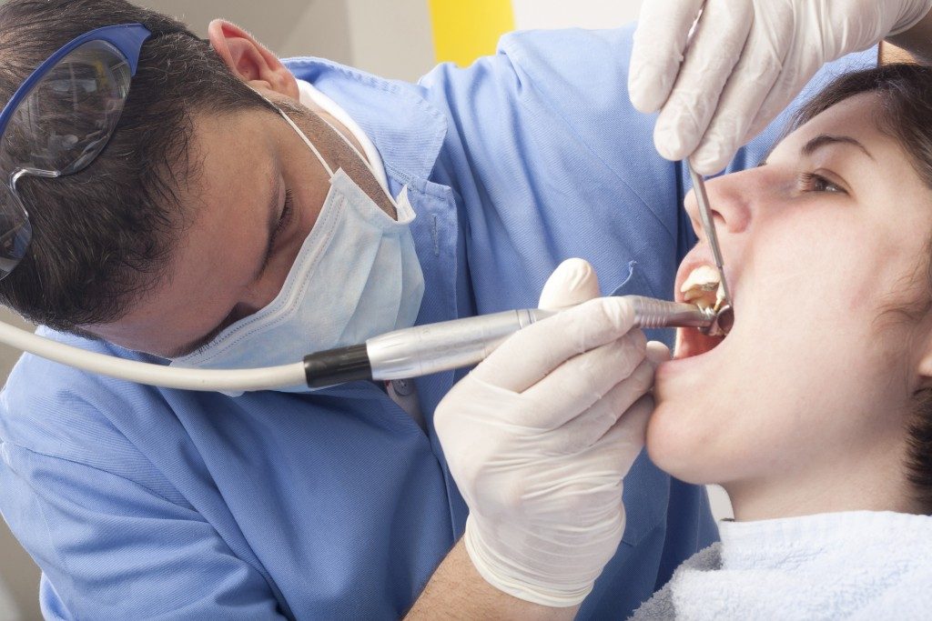 a dentist cleaning his patient's teeth