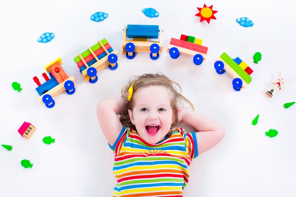 Toddler playing with wooden toys