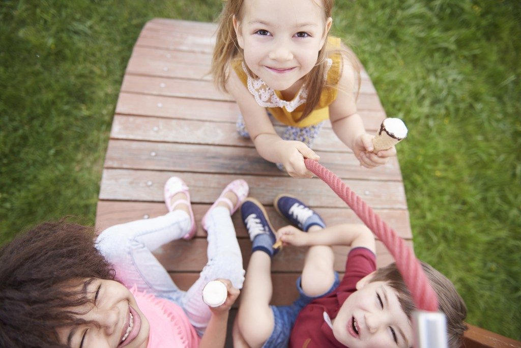 kids playing at the playground while eating ice cream