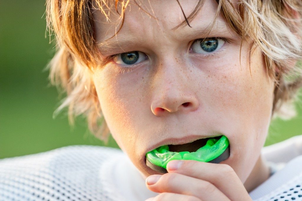 kid with mouthguard for sports