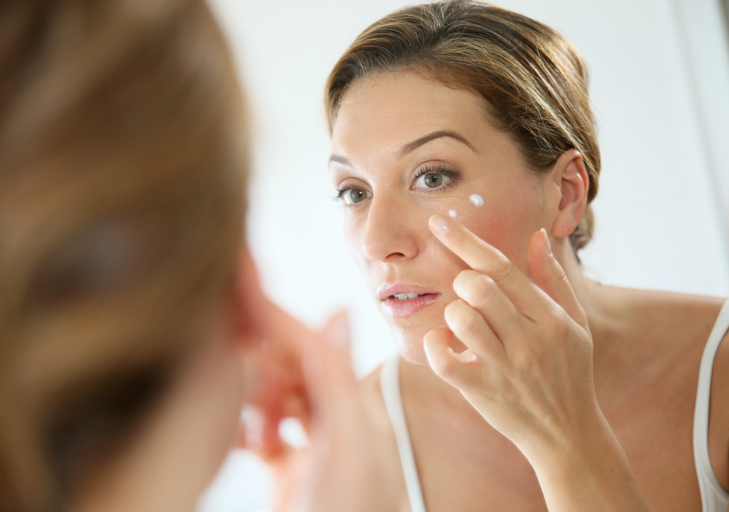 woman applying moisturizer