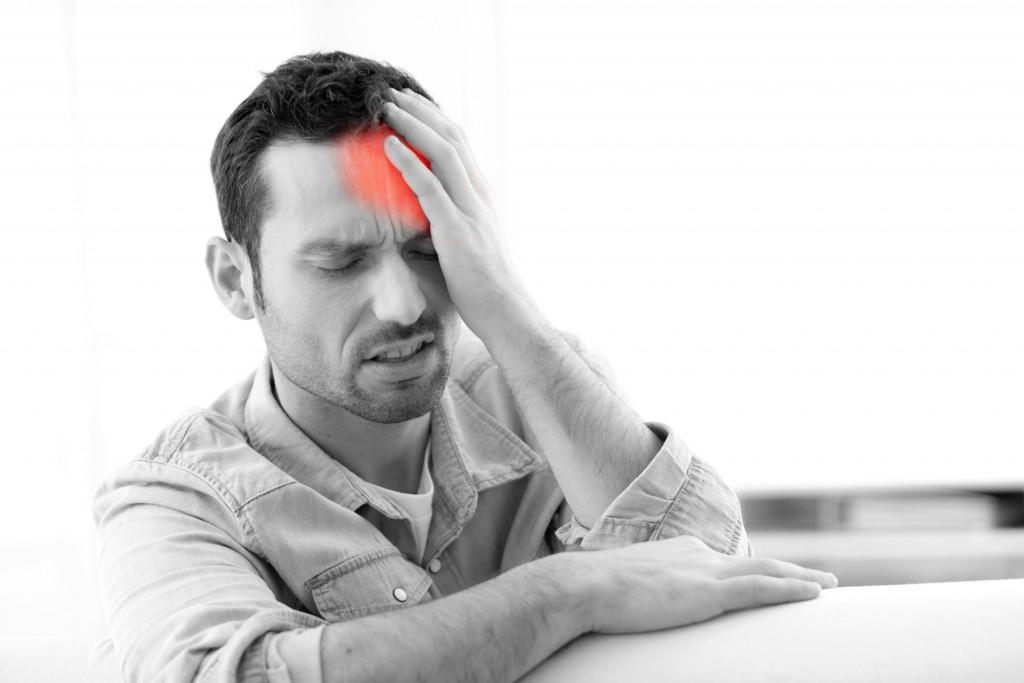 A man holding his head shown in red