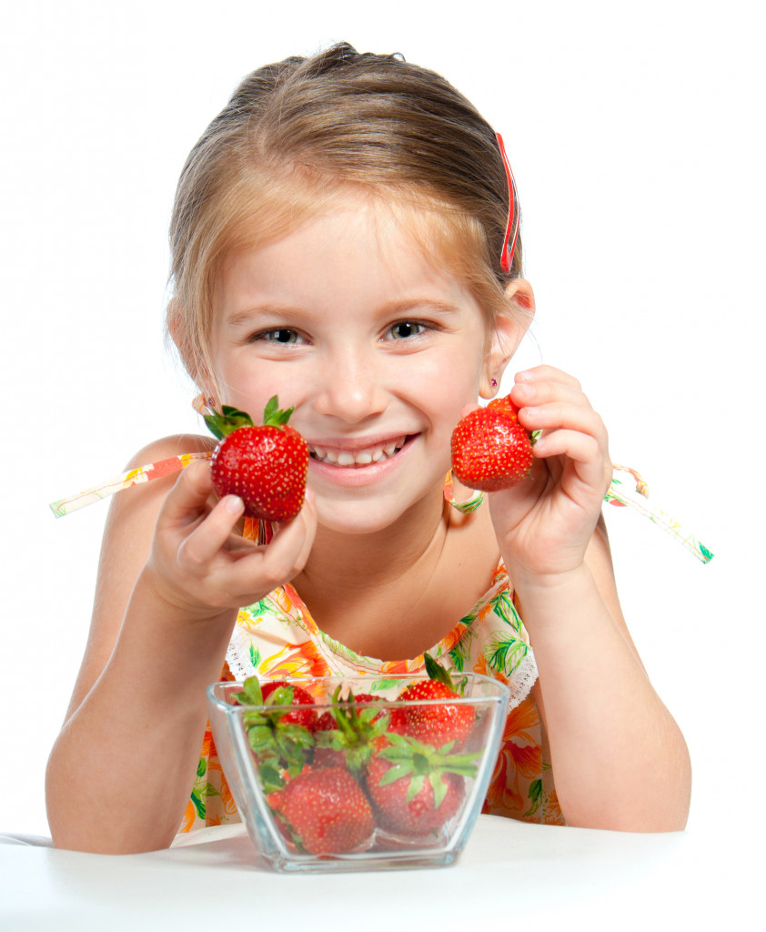 baby girl holding strawberry