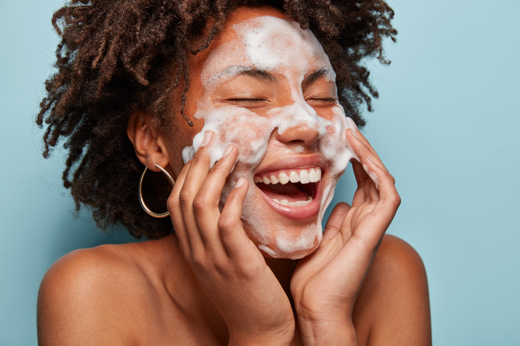 A woman using a foam cleanser on her face